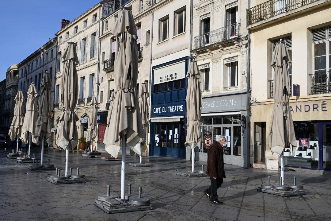 Una persona pasea por una calle con los restaurantes cerrados por la pandemia de COVID-19