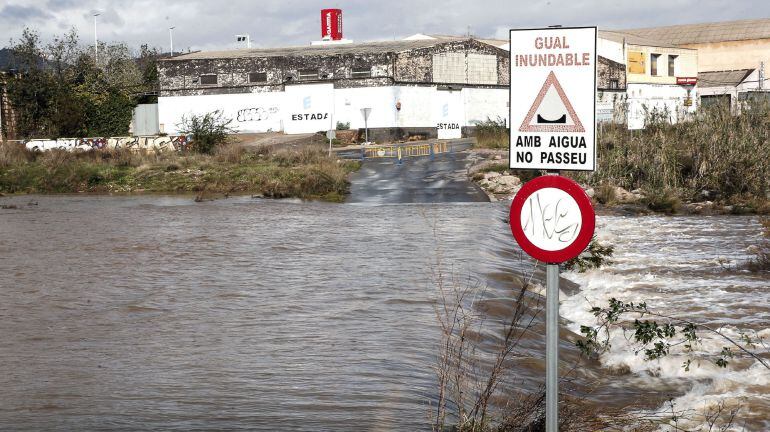La Policía local de Sagunto ha cortado esta carretera que cruza el cauce habitualmente seco del barranco del río Palancia en Sagunto tras su crecida por las lluvias.