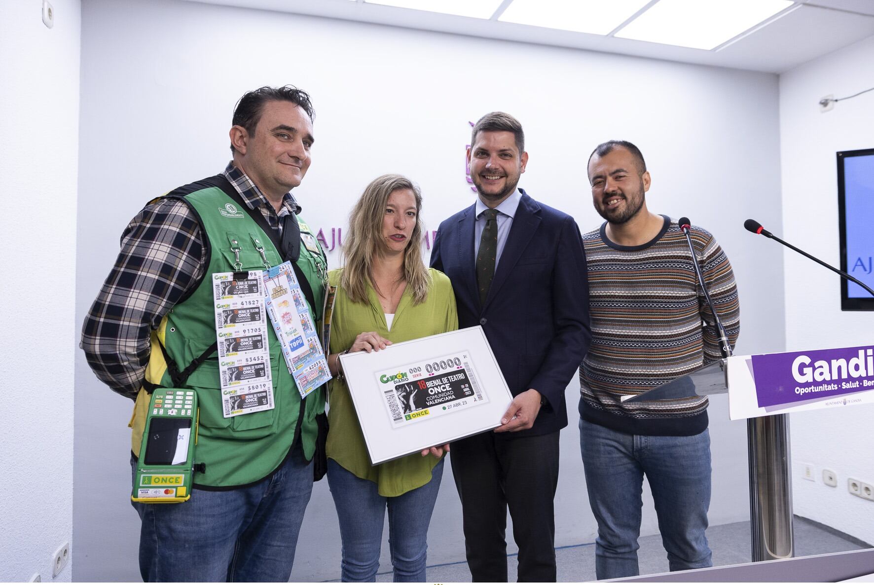 Las autoridades municipales de Gandia y representantes de la ONCE posando con el cupón conmemorativo.