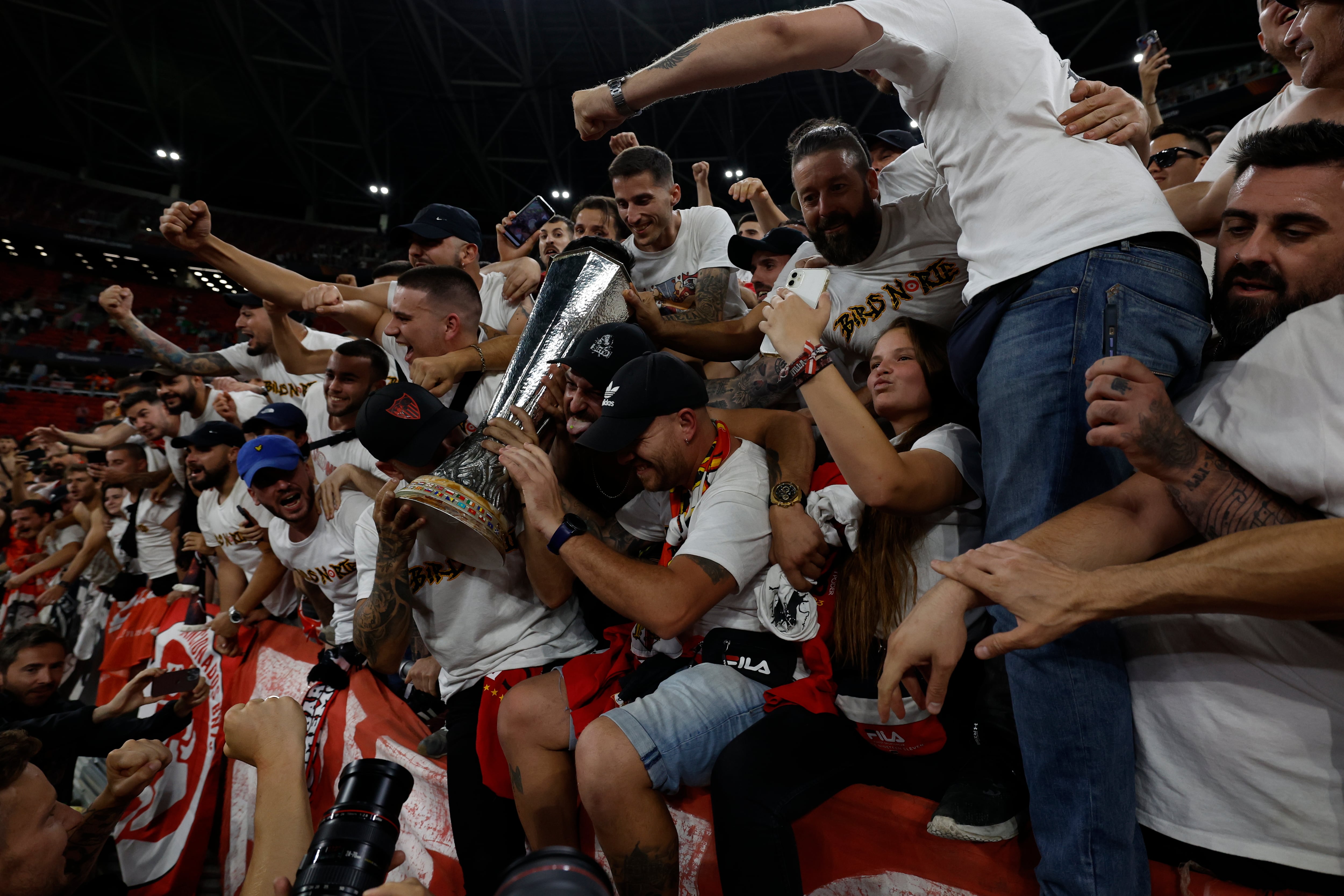 El centrocampista croata del Sevilla, Ivan Rakitic (i), celebra con los aficionados del Sevilla su triunfo en la final de la Europa League tras derrotar a la Roma en la tanda de penaltis del encuentro que han disputado este miércoles en el Puskas Arena de Budapest (Hungría).