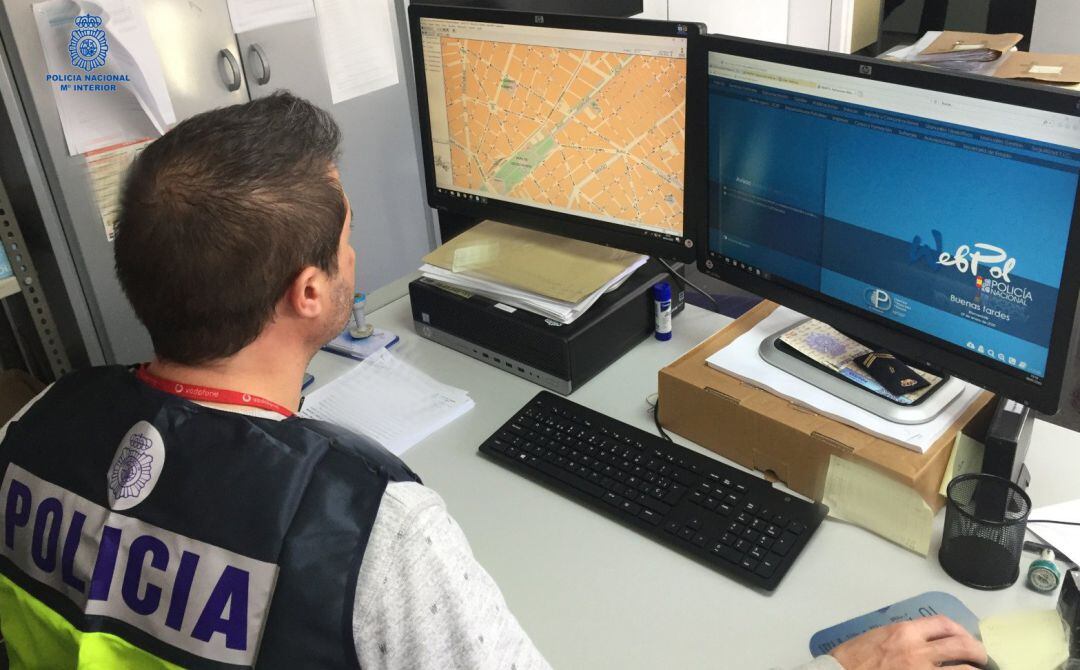 Un policía nacional frente a un ordenador.