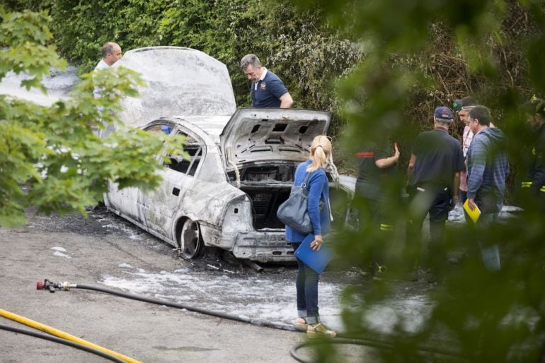 Efectivos policiales junto al vehículo quemado en el que se ha encontrado el cadáver 