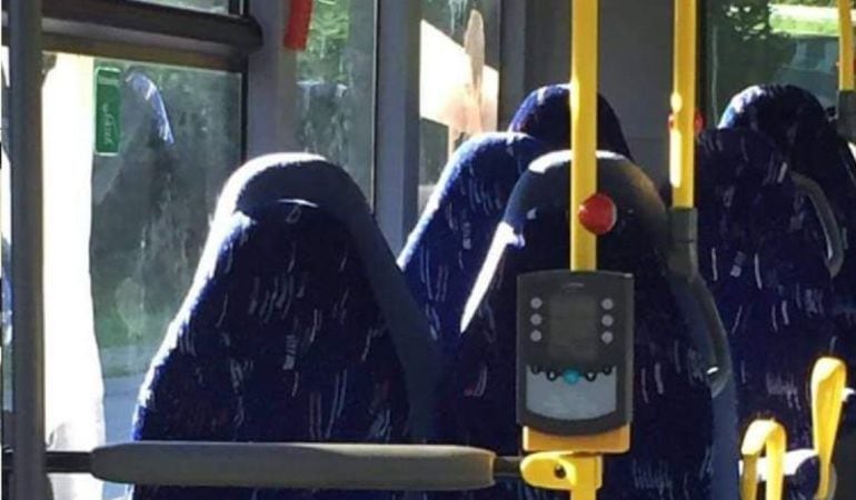 Fotografía de los asientos vacíos de un autobús que fueron confundidos con seis mujeres con burka por un grupo racista de Facebook. 