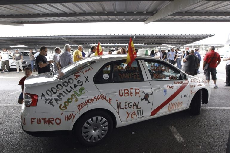 GRA215. MADRID, 09/12/2014.- Fotografía de archivo, del 11/06/2014, de un taxi con pintadas en protesta por el intrusismo y la &quot;ilegalidad&quot; de aplicaciones de teléfonos móviles como Uber. El Juzgado de lo Mercantil número 2 de Madrid ha ordenado hoy caute