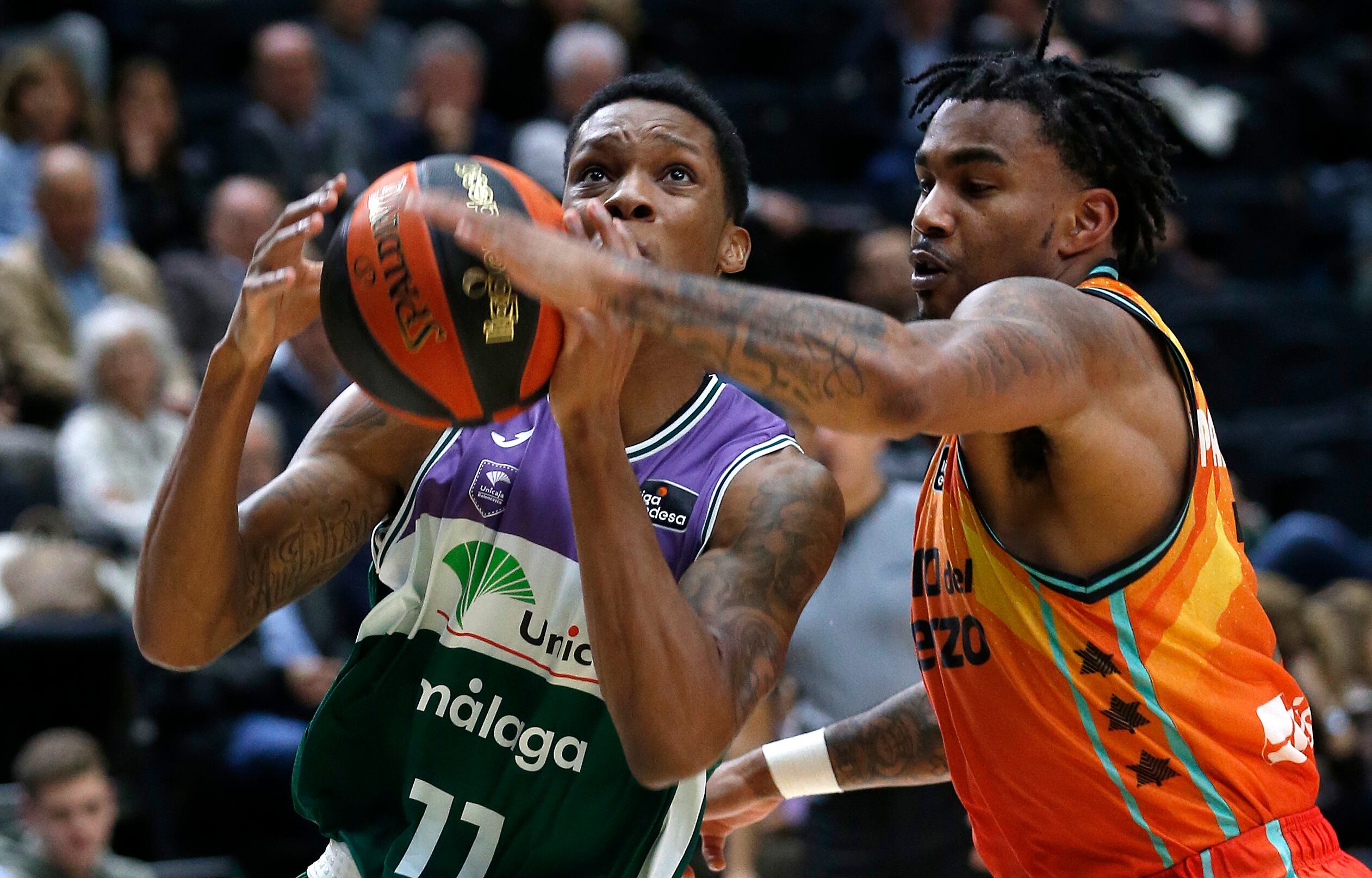 GRAFCVA9976. VALENCIA, 27/11/2022.-El jugador del Valencia Basket, Chris Jones (d) y Tyson Carter (i) , del Unicaja Málaga, durante el encuentro entre ambos equipos disputado hoy en el pabellón de la Fuente de San Luis de Valencia correspondiente a la J9 de la Liga Endesa EFE/Miguel Ángel Polo