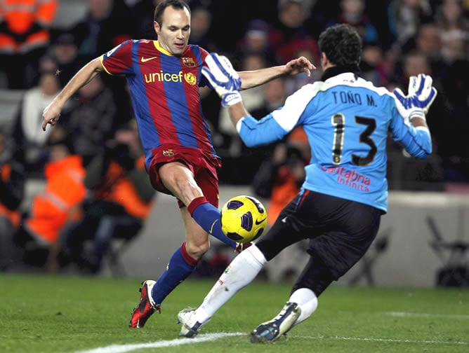 Andrés Iniesta chuta ante el portero del Racing de Santander Toño durante el partido correspondiente vigésima jornada del Campeonato Nacional de Liga