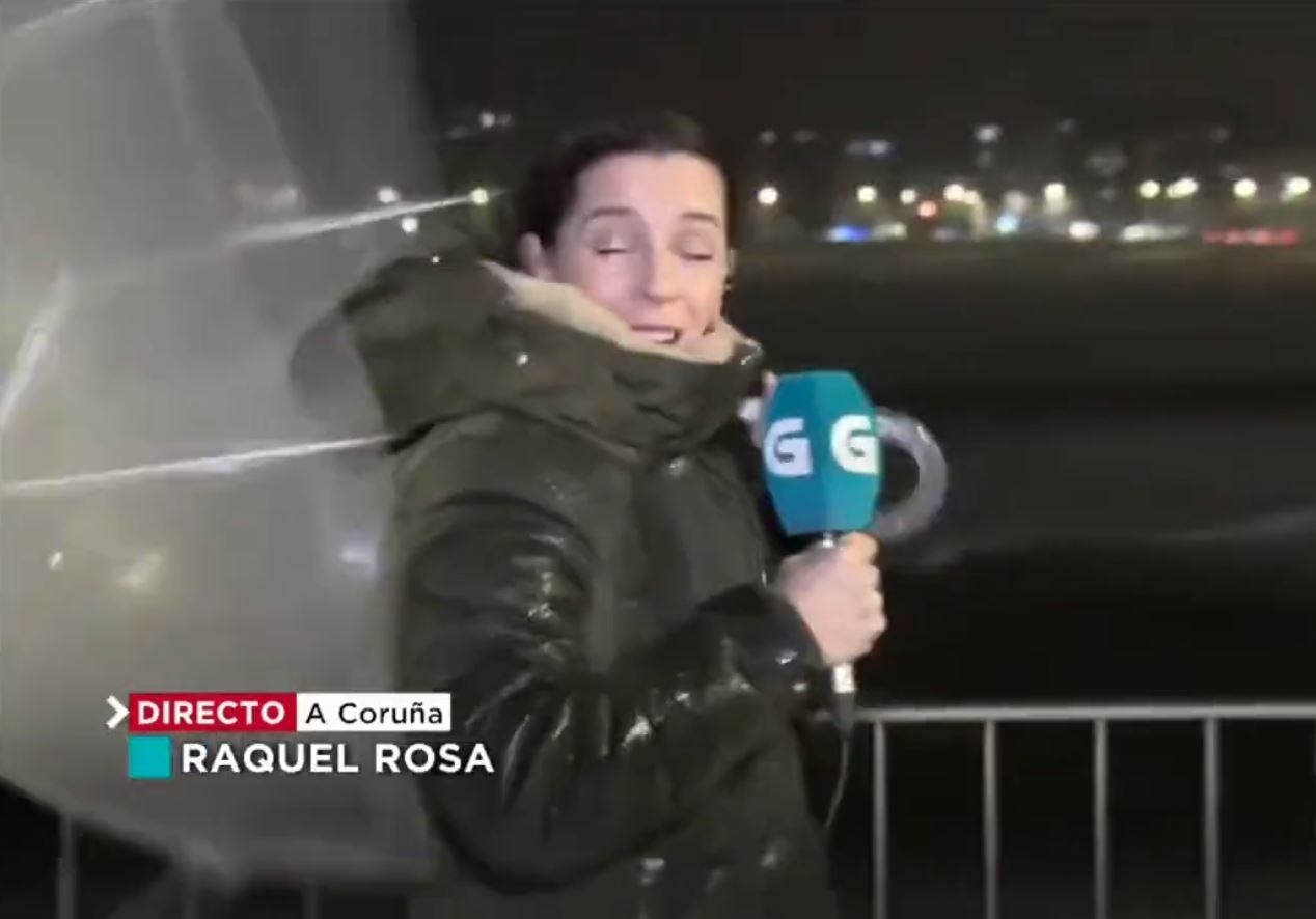 La reportera Raquel Rosa tratando de aguantar su paraguas frente al viento