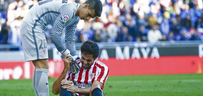 El defensa del Athletic de Bilbao Xabier Etxeita (d) se duele tras una jugada, junto al portero Kepa Arrizabalaga (i), durante el partido frente al Espanyol de la undécima jornada de la Liga de Primera División disputado hoy en el RCDE Stadium de Cornellà