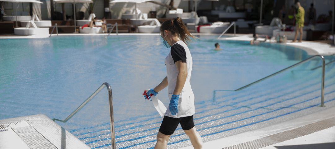 Archivo - Una trabajadora realiza tareas de desinfección en una piscina.