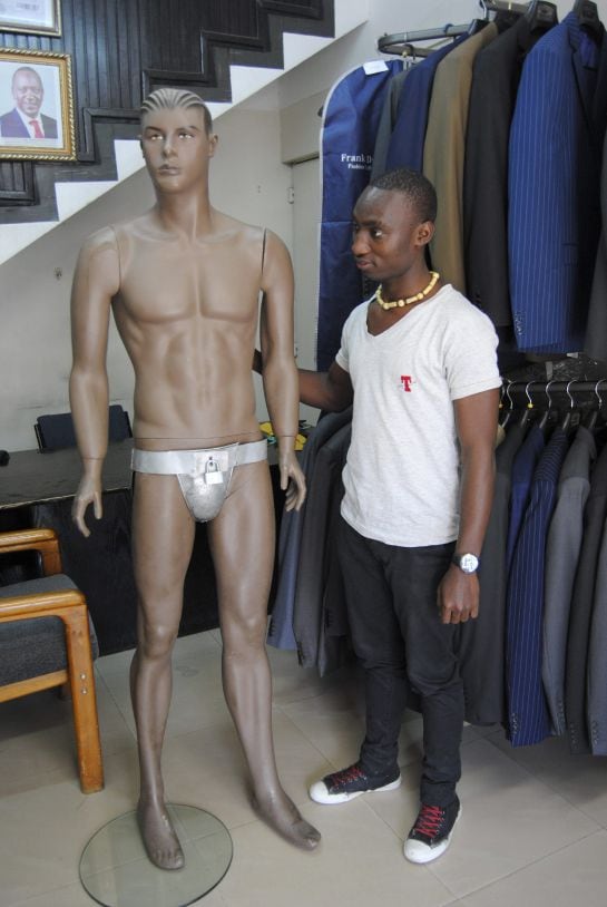 Kelvin Omondi (d), trabajador de la céntrica tienda Kings Castle de Nairobi, posa junto un maniquí desnudo que luce el cinturón de castidad.