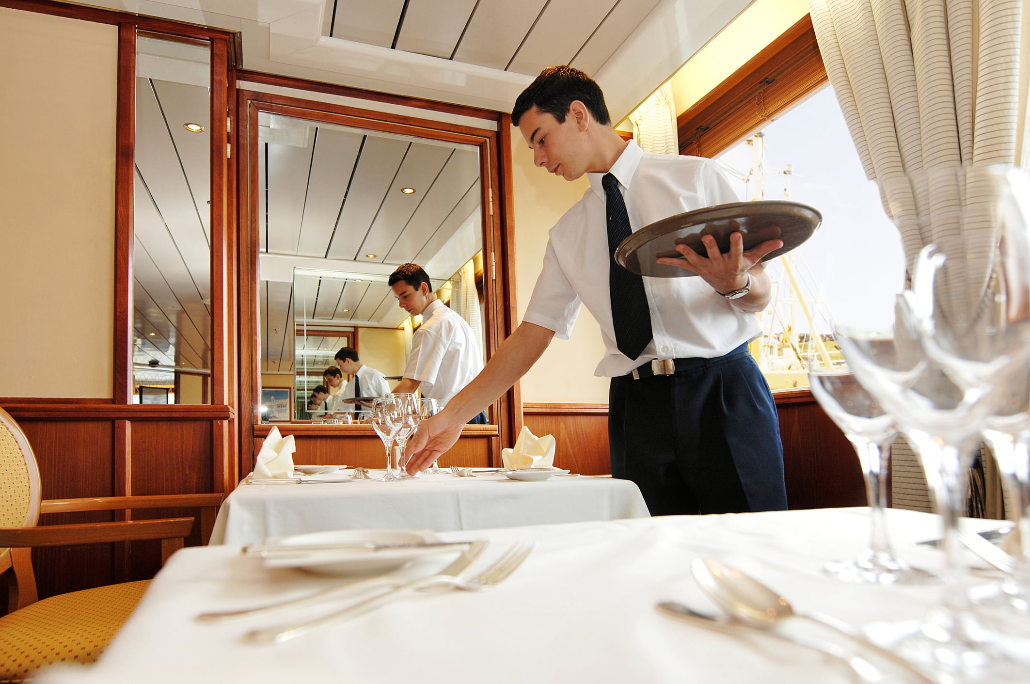 Camarero poniendo el servicio en la mesa de un restaurante.