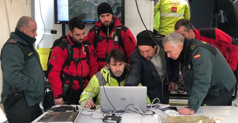 Miembros del Grupo de Emergencias de Andalucía junto a guardias civiles en el puesto de mando que se ha instalado para buscar al hombre desaparecido.