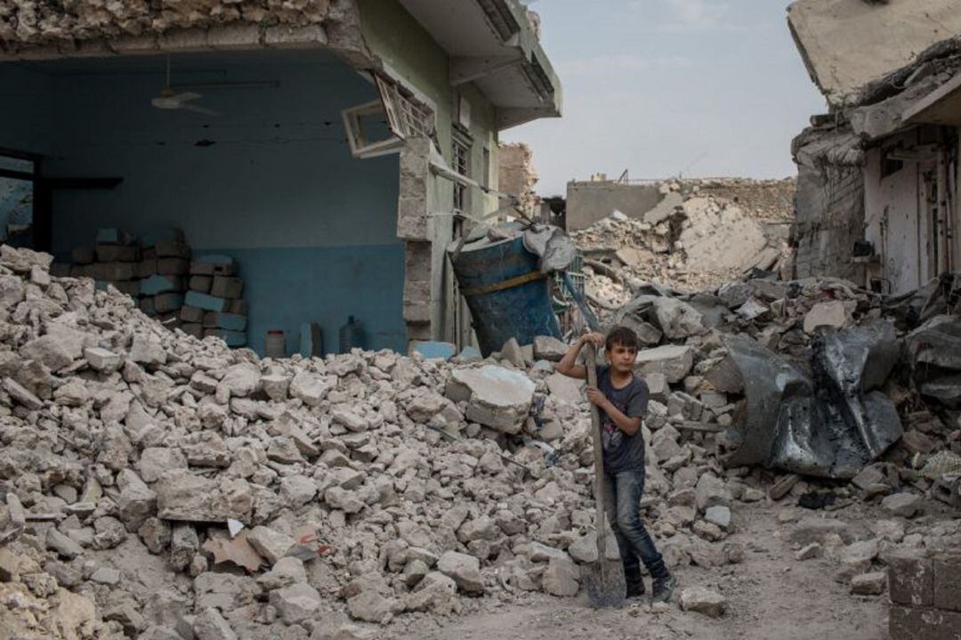 Un niño limpia restos de una vivienda en la ciudad de Mosul, el principal bastión del ISIS en Iraq entre 2014 y 2017