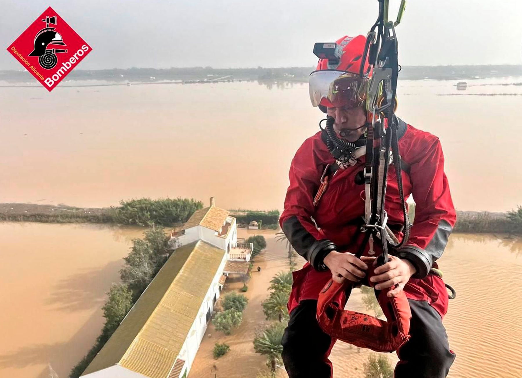 Un bombero en el helicóptero dispuesto a rescatar a afectados por las inundaciones