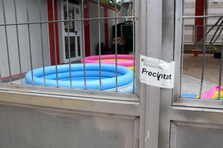 La tanca de la llar d&#039;infants amb el precinte dels Mossos d&#039;Esquadra, i les piscines instal·lades al pati