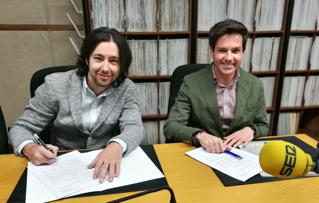 Luis Hernández (izda) y Carlos Miguelsanz en el momento de la firma en el estudio de Radio segovia