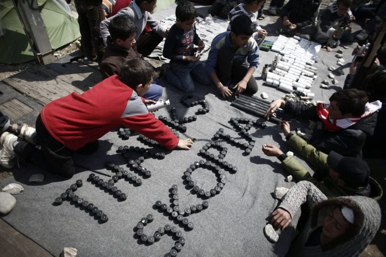 Un grupo de niños escribe &quot;Gracias, Skopje&quot; con algunos de los botes de gas lacrimógeno empleados ayer por la policía de Macedonia contra un grupo de refugiados en Idomeni, Grecia.