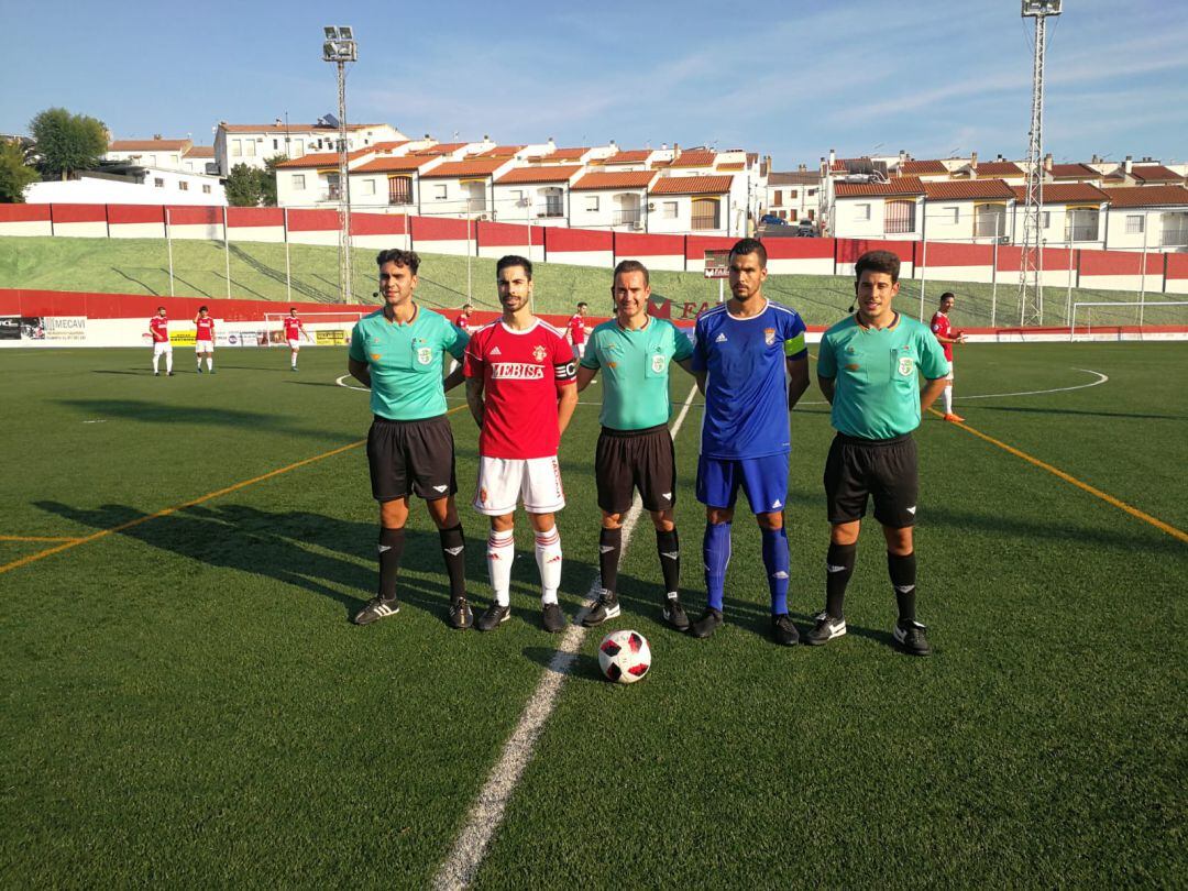 Los capitanes de los dos equipos junto al trío arbitral antes del partido