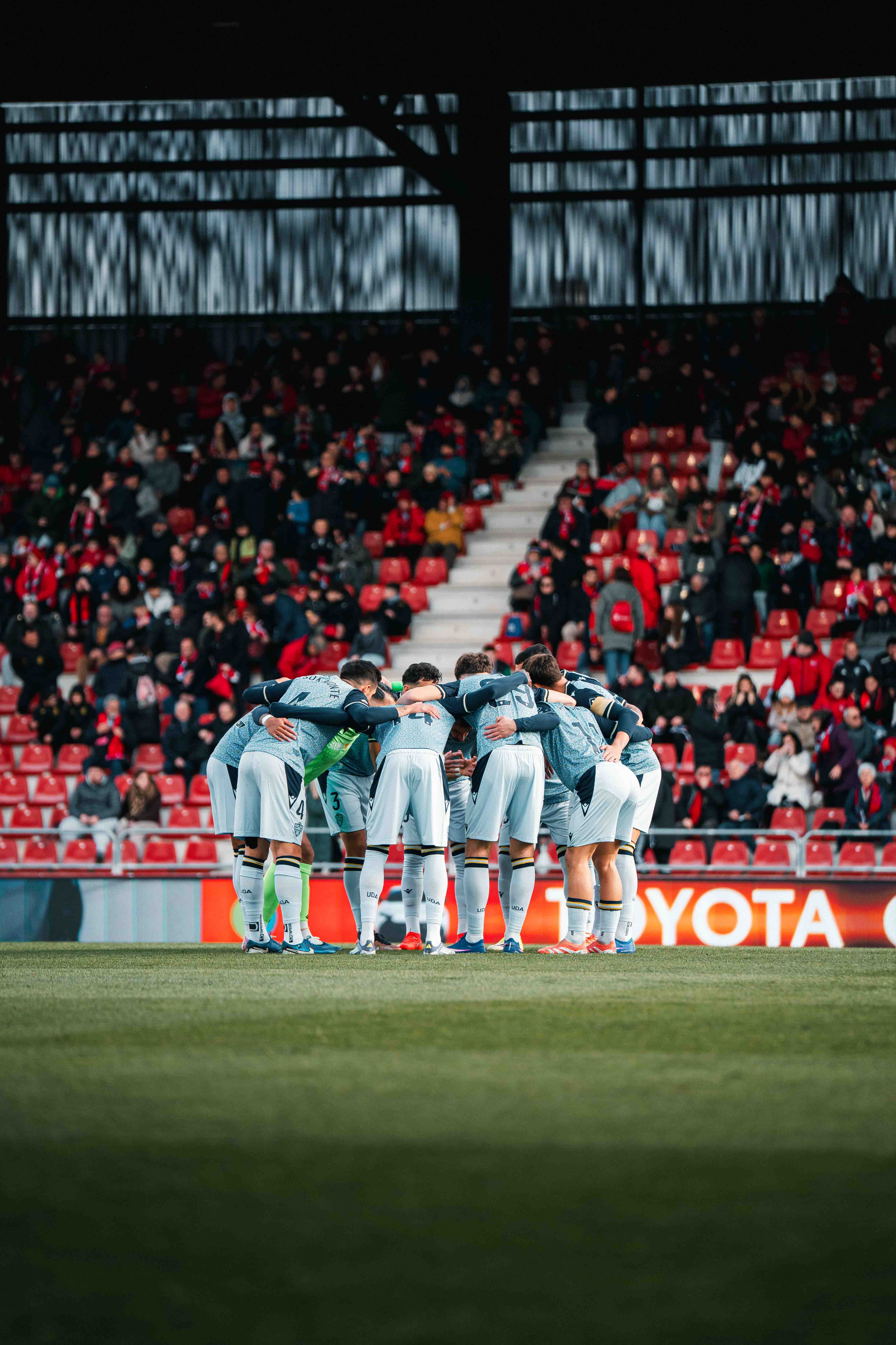 Los futbolistas del Almería hacen la piña antes del partido en Anduva.