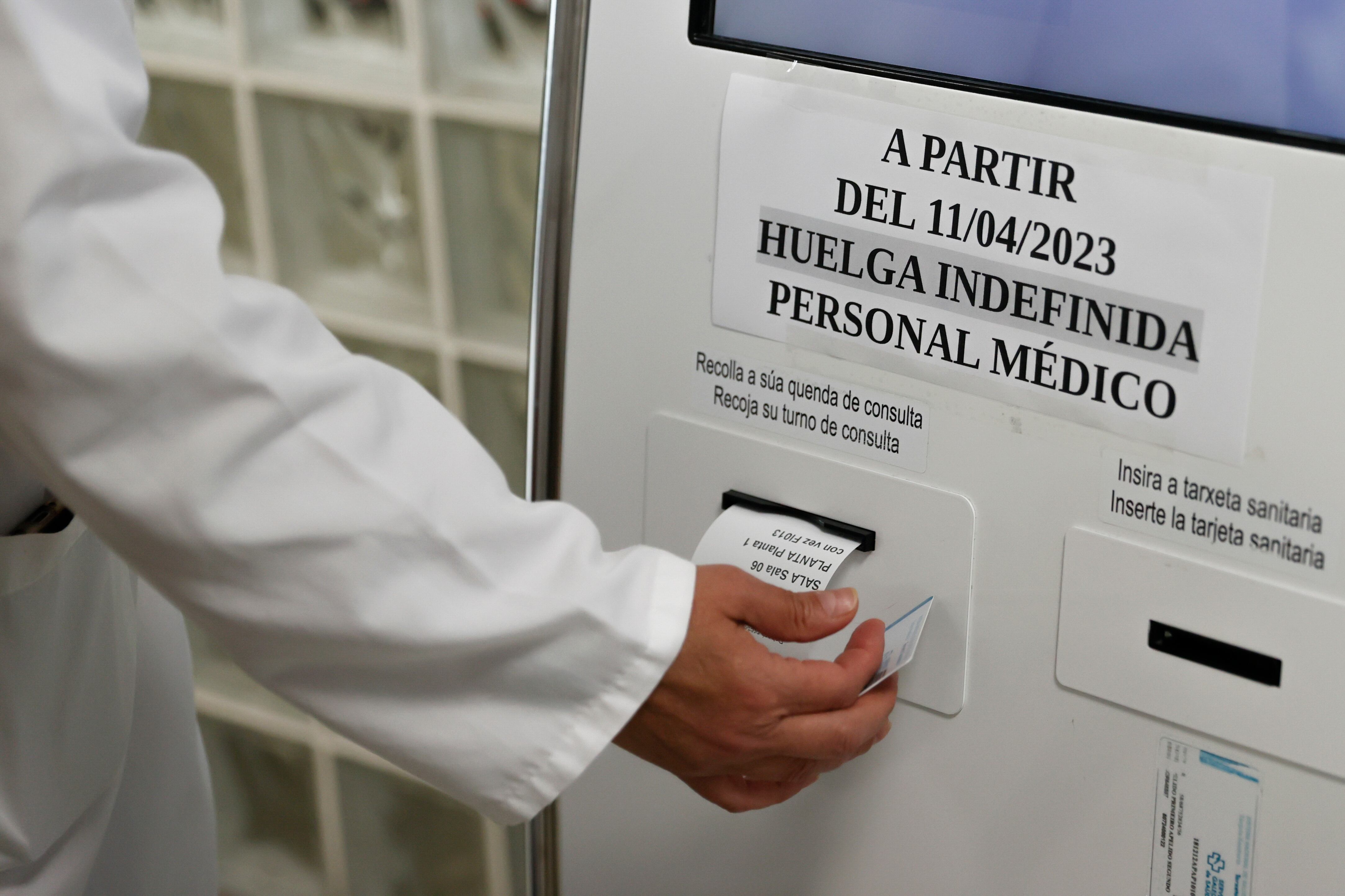 SANTIAGO DE COMPOSTELA, 11/04/2023.- Un médico ayuda a un paciente para conseguir una cita en la máquina en un centro de salud, este martes en Santiago de Compostela. Los médicos de Galicia están en huelga indefinida desde esta medianoche, que se suma a la que reanudaron ayer los sanitarios de Ceuta y Melilla tras el parón de la Semana Santa. EFE/ Lavandeira Jr
