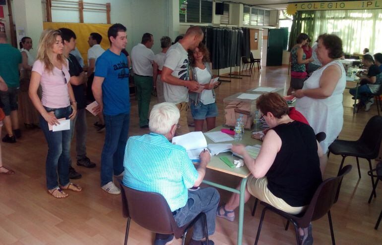 Varios electores en el colegio Iplacea de Alcalá de Henares
