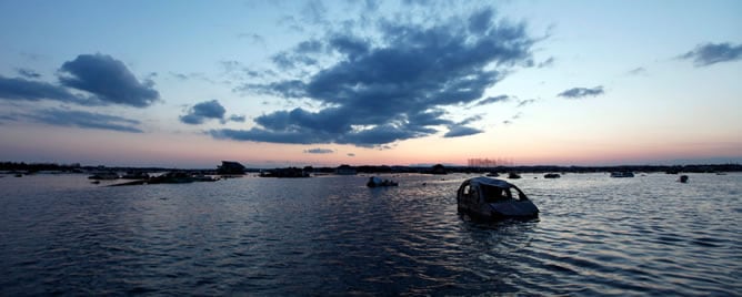 Un coche parcialmente hundido en un campo de arroz, tras el tsunami que devastó el área de Higashi-Matsushima, en Japón