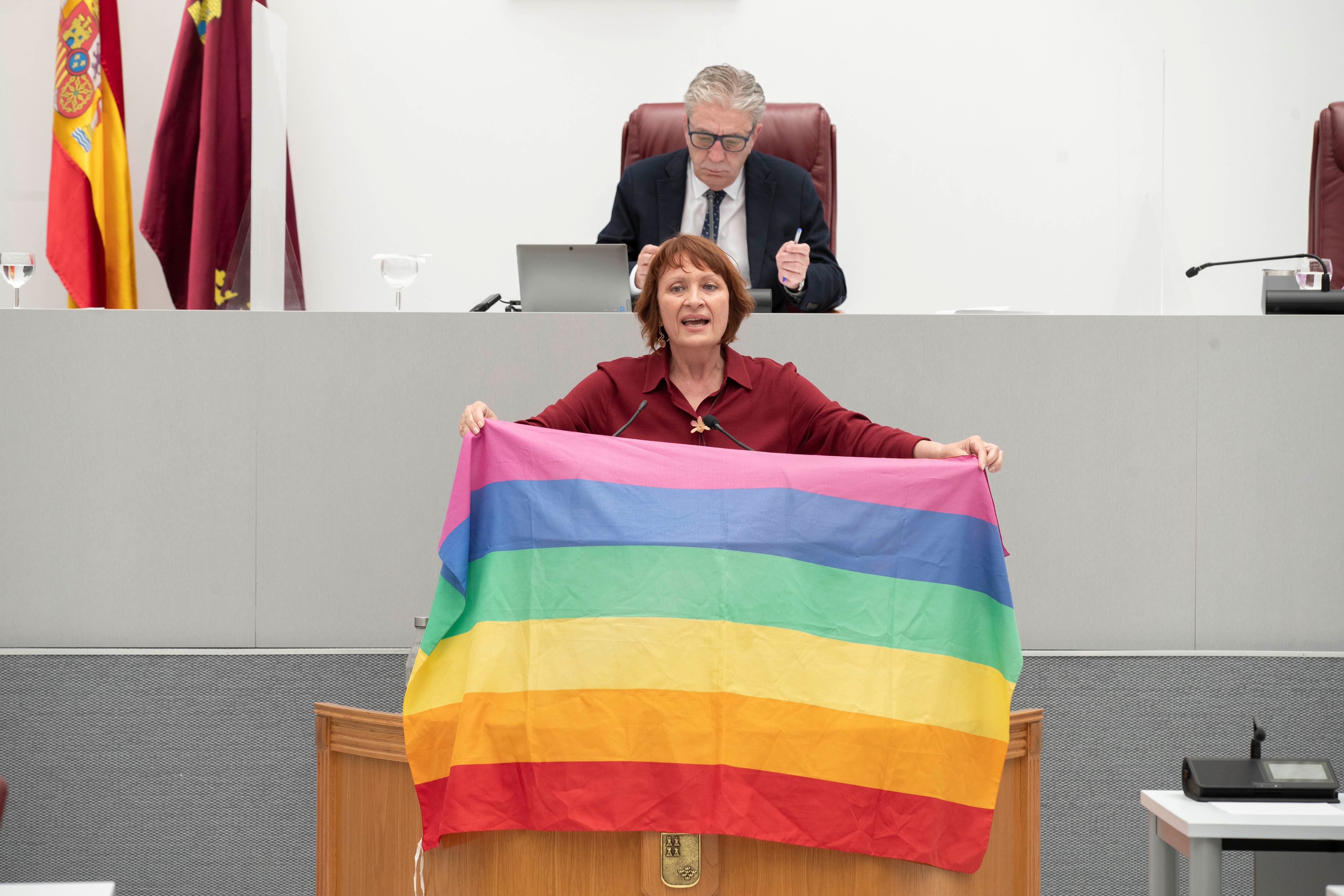 La portavoz de Podemos, María Marín, ha desplegado la bandera LGTBI durante su intervención en la Asamblea Regional