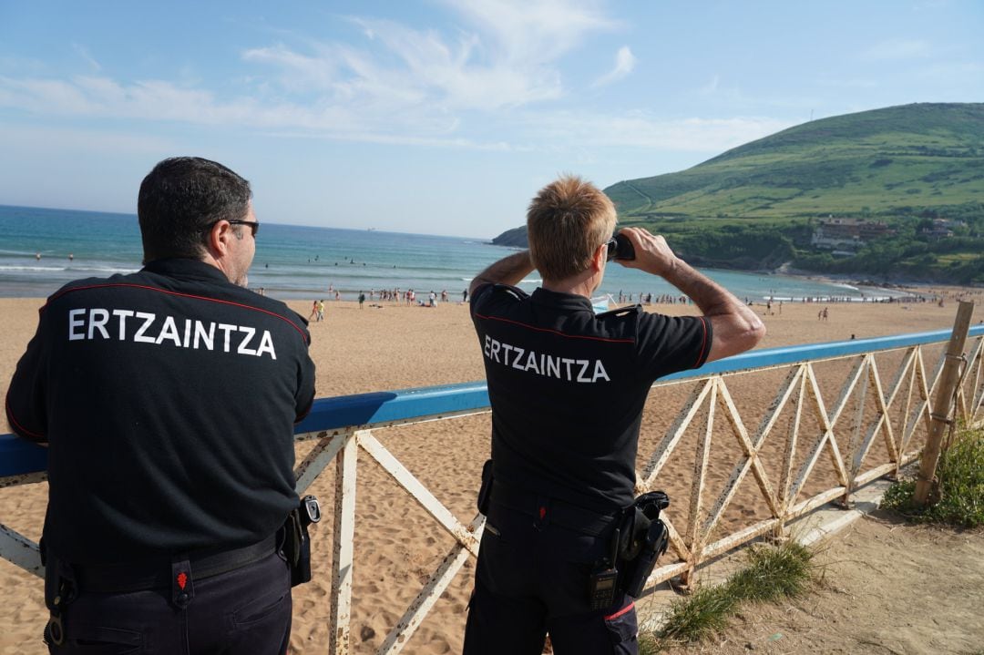 Dos ertzaintzas vigilan la playa de La Arena