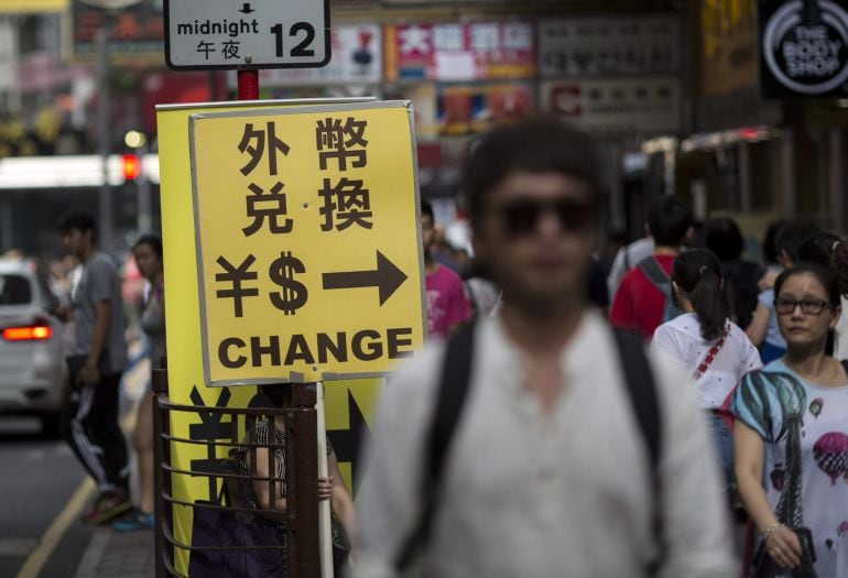 Un gran número de personas caminan por las calles de Hong Kong, China, repletas de coches. 