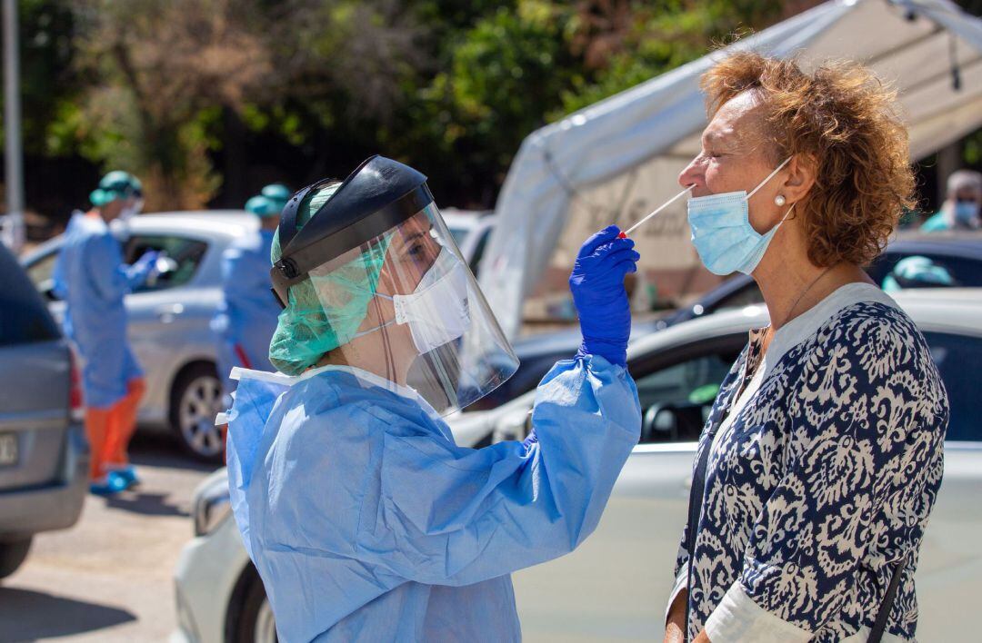 Une enfermera realizando una prueba PCR a una ciudadana.