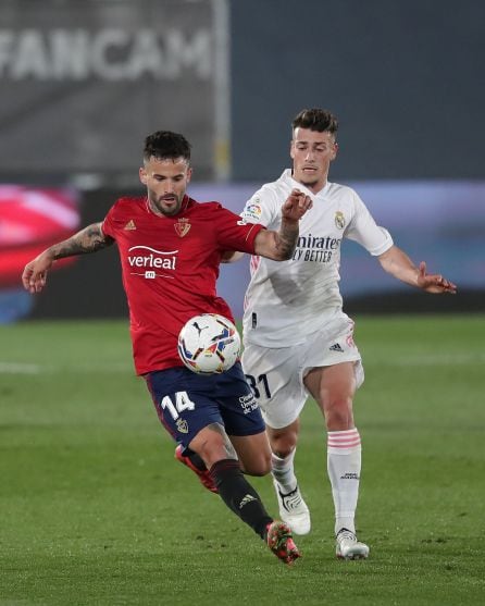 Antonio Blanco, del Real Madrid disputando el balón contra Rubén García, de Osasuna.