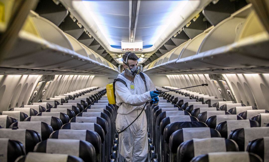 Un operario desinfecta el interior de un avión.