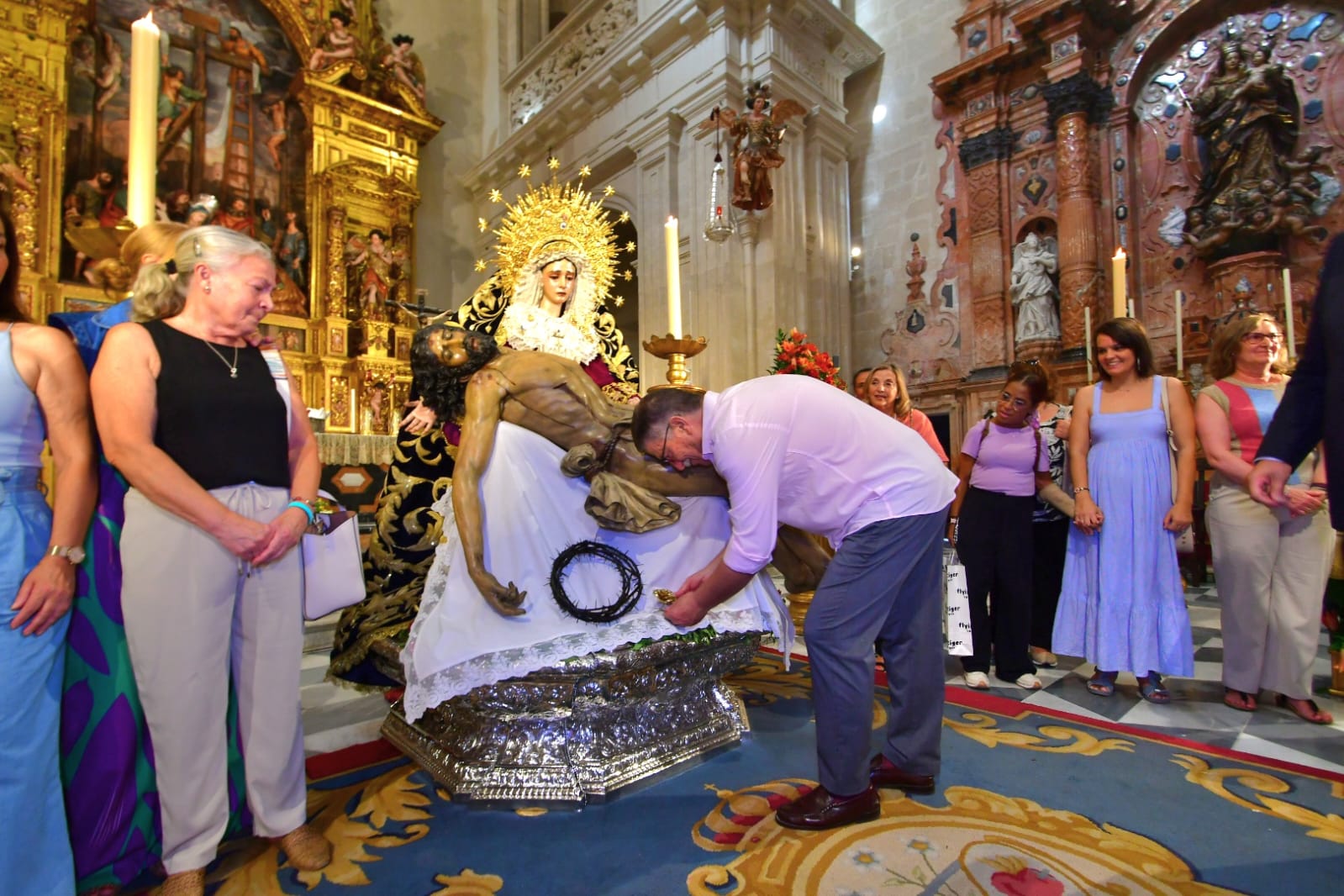 Lolo Gómez coloca la Rosa de Pasión de Cruz de Guía a las plantas de la Virgen de la Piedad y el Cristo de la Misericordia