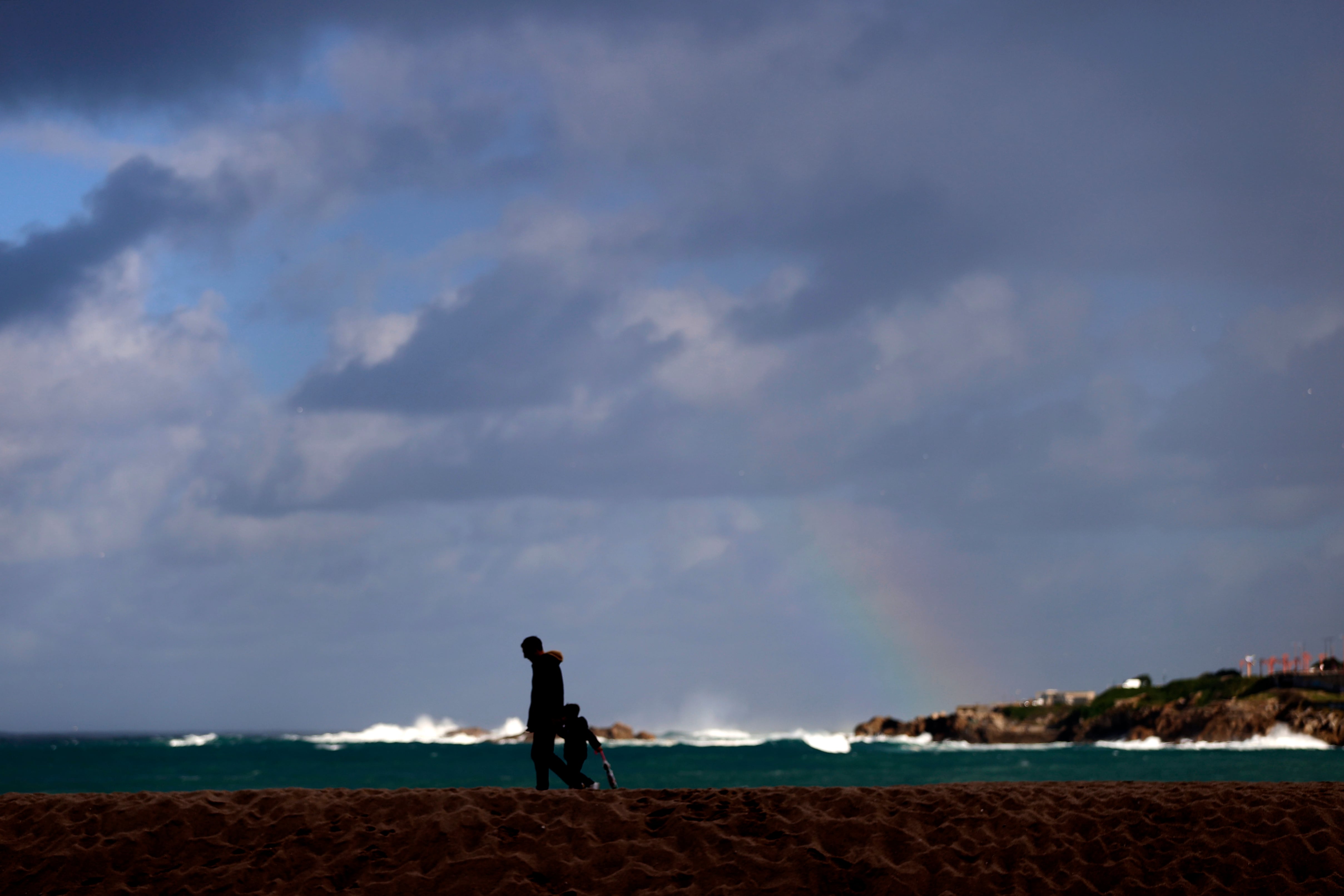 25/01/2025.- Un hombre caminaba con un niño este sábado por la playa de Riazor, en A Coruña