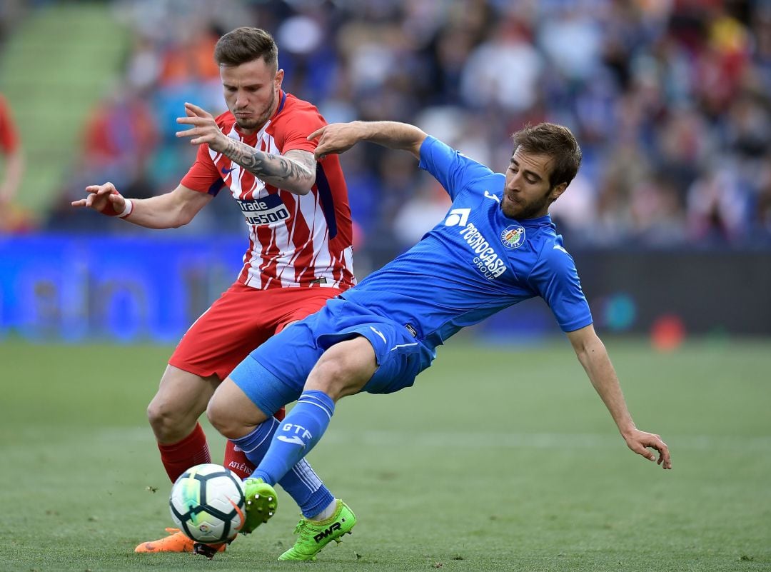 Mathieu Flamini (Getafe C.F.) compite por un balón con Saúl Ñíguez (C. Atlético de Madrid) durante un partido de la temporada pasada.