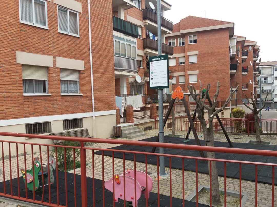 Cartel con normas de uso en un pequeño espacio de juegos infantil en el centro de Cuéllar