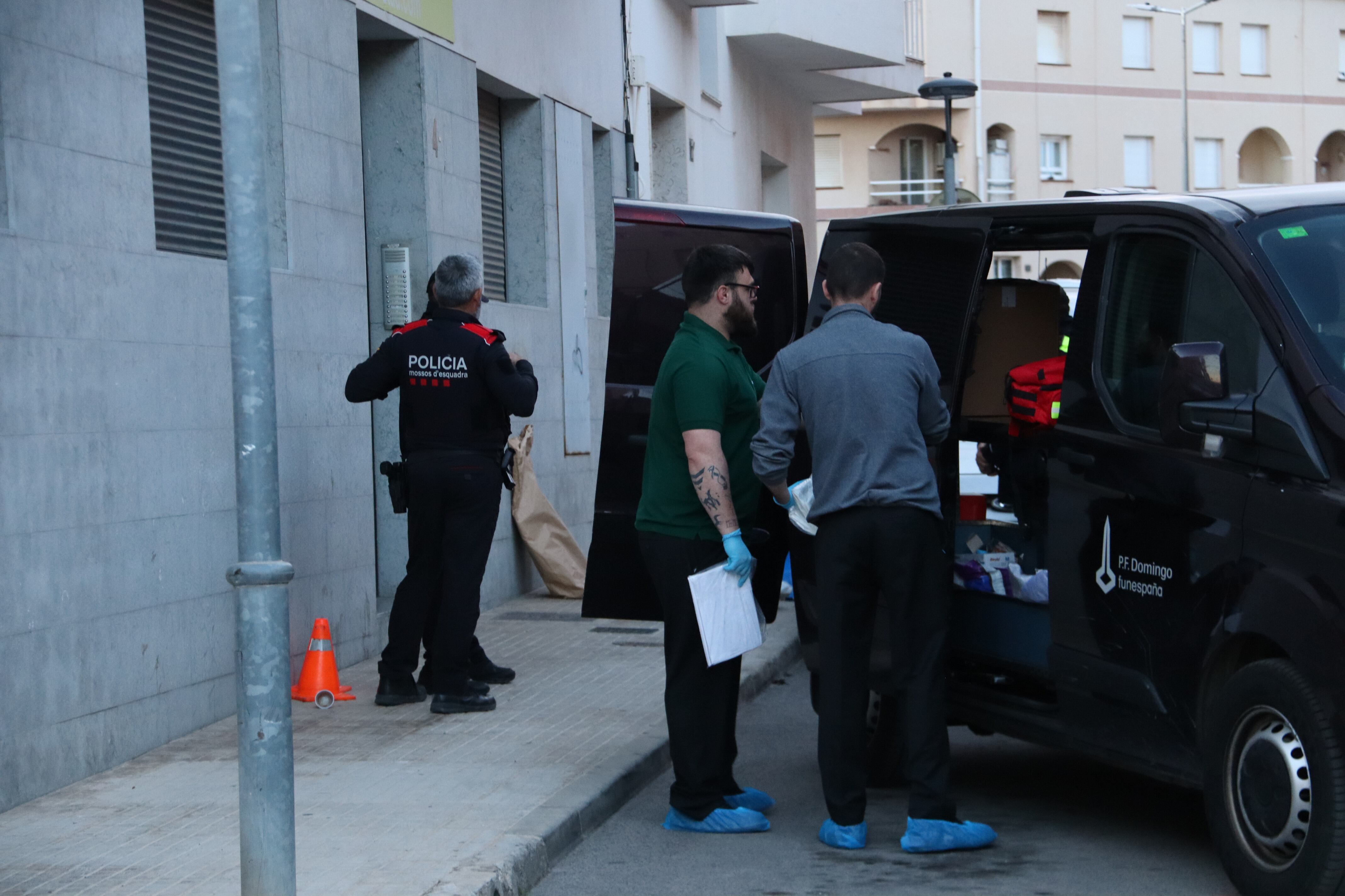 Imatge de l'exterior de l'edifici del carrer Xile d'Amposta on s'ha trobat el cos, amb la presència de la funerària.