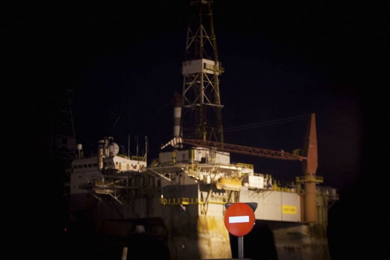 An oil rig is pictured during a protest against the begining of oil prospecting by Spanish group REPSOL off the shores of Spain&#039;s Canary Islands, in Santa Cruz de Tenerife on November 14, 2014. Greenpeace said activists on its Arctic Sunrise protest boat sailed to the zone where they expected Spanish oil group Repsol to launch its explorations this weekend, vowing to block the prospecting vessel. Local groups meanwhile called rallies on Friday right across the Atlantic archipelago, whose beaches are a popular draw for foreign tourists from Britain, France and elsewhere.  AFP PHOTO / DESIREE MARTINDemonstrators hold a banner as they wait for the arrival of ??the survey ship Rowan Reinaissance