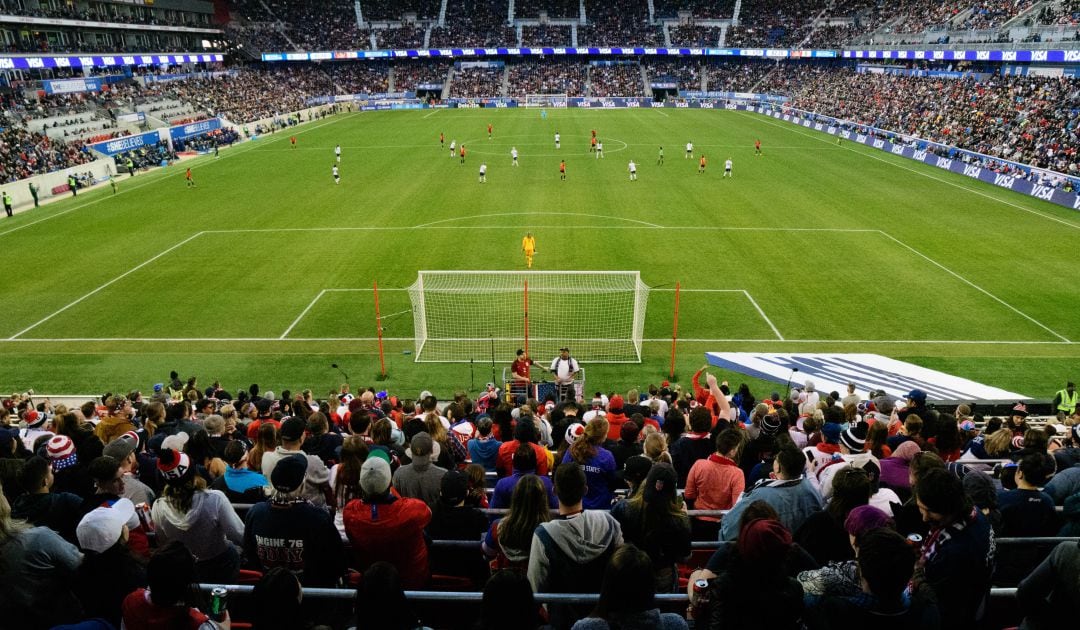 Un partido de fútbol visto desde las gradas de aficionados.