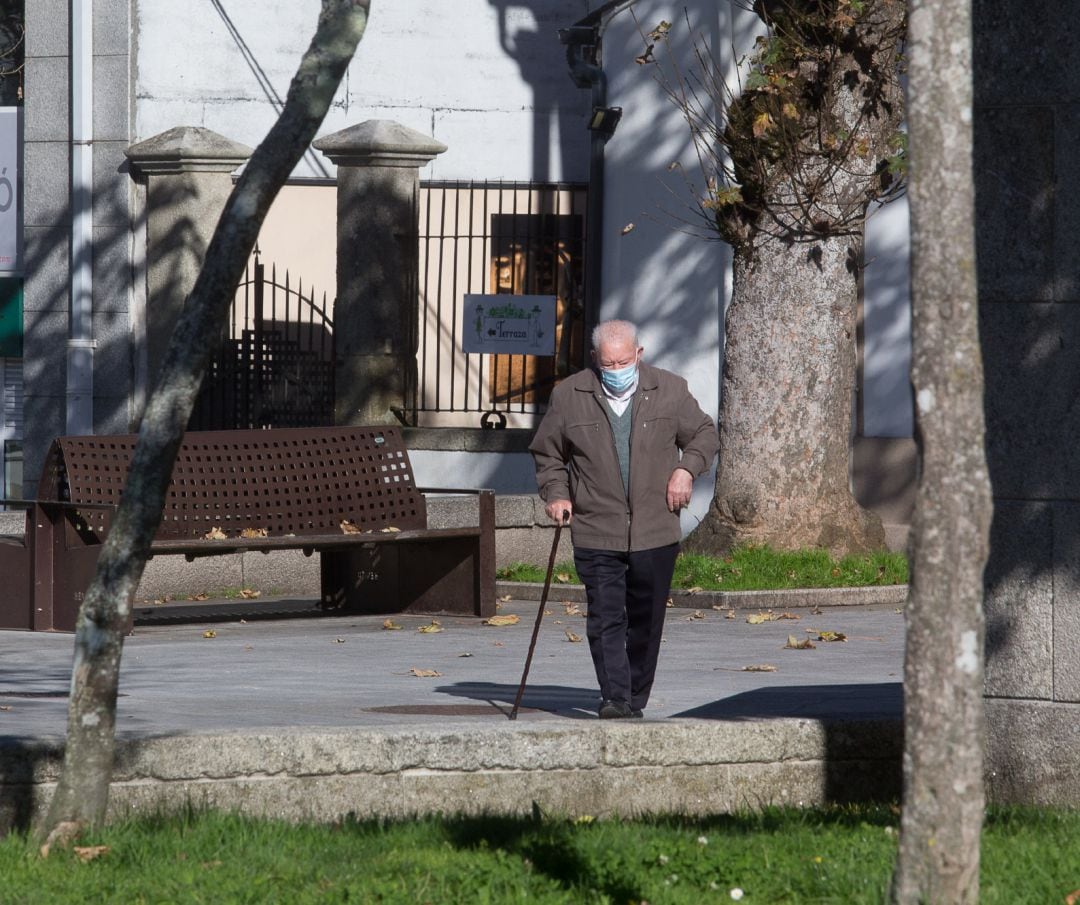 Un anciano camina por una  calle