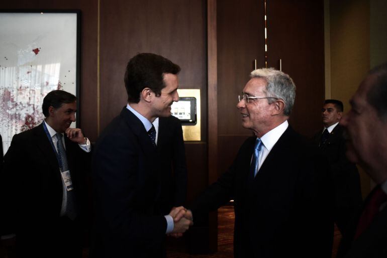 El presidente del Partido Popular español, Pablo Casado (i), saluda al expresidente colombiano Álvaro Uribe Vélez