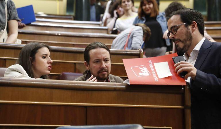 El secretario general de Podemos, Pablo Iglesias, conversa con la portavoz de su grupo, Irene Montero (i), y el líder de IU, Alberto Garzón durante la primera sesión del primer día de debate de totalidad al proyecto de Ley de Presupuestos Generales del Estado de 2018.