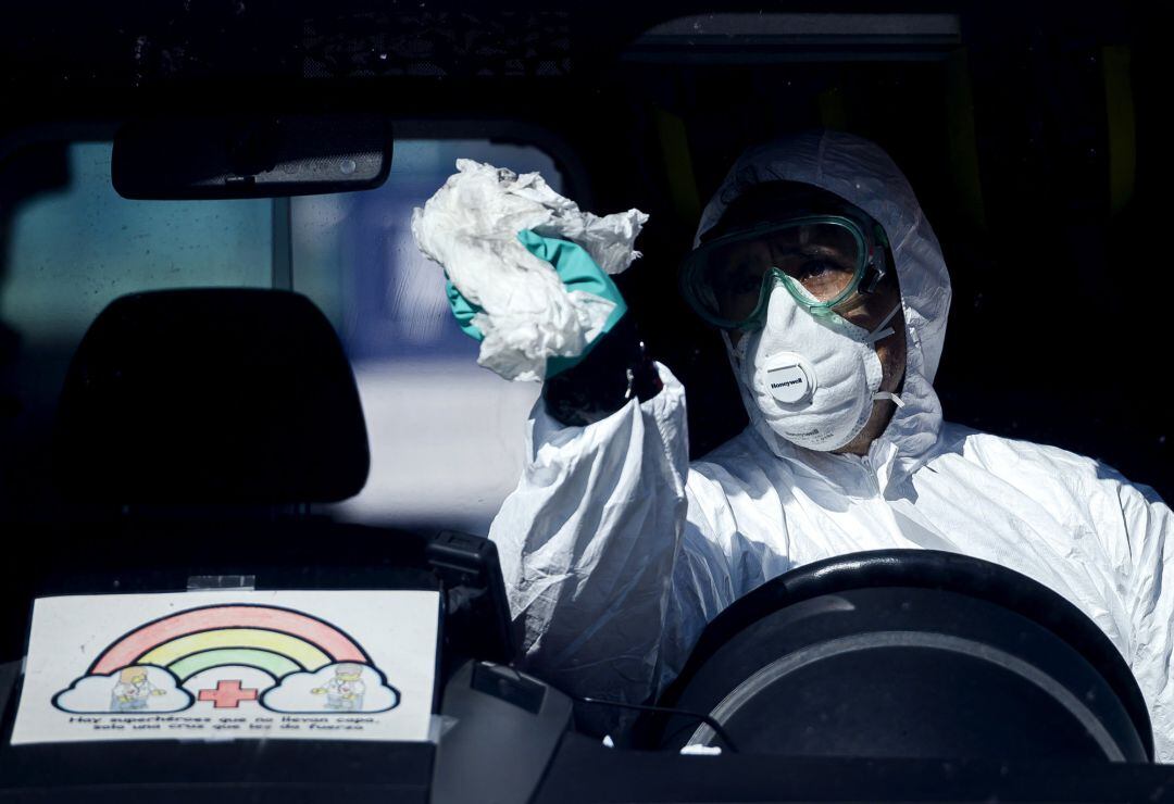 Un profesional sanitario desinfectando una ambulancia 