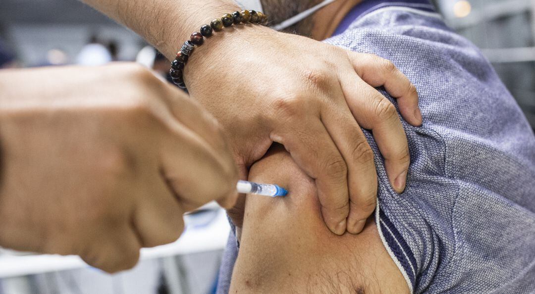 Un sanitario administra una dosis de la vacuna de Pfizer.