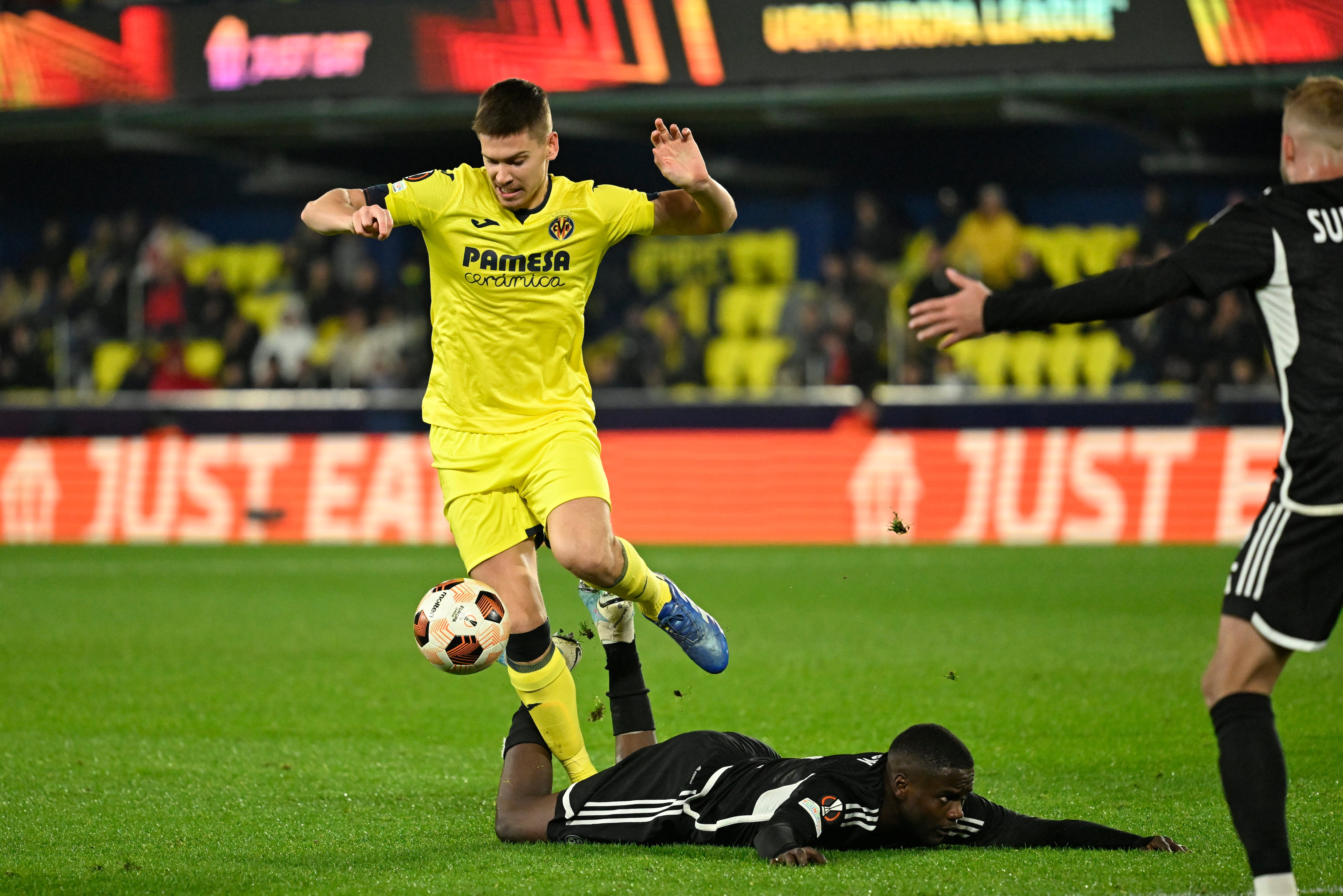 VILLARREAL (CASTELLÓN), 06/12/2023.- El centrocampista del Maccabi Haifa Manuel Show (d) cae junto a Juan Foyth , del Villarreal, durante el encuentro correspondiente a la fase de grupos de la Liga Europa que Villarreal y Maccabi Haifa disputan hoy miércoles en el estadio de La Cerámica de la localidad castellonense. EFE / Andreu Esteban.
