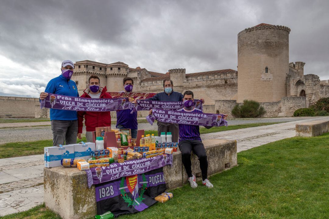 La junta directiva de la Peña Blanquivioleta de Cuéllar muestra distintos alimentos en las cercanías del castillo