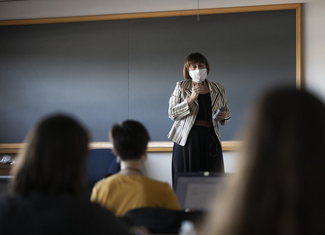 Una profesora imparte clase de manera presencial 