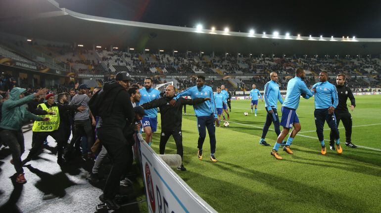 Evra es separado por sus compañeros de la grada donde estaba el aficionado al que agredió con una patada.