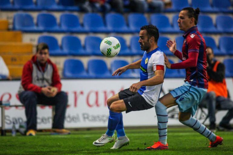 Paco Peña controla un balón ante la presencia de un jugador del At. Levante