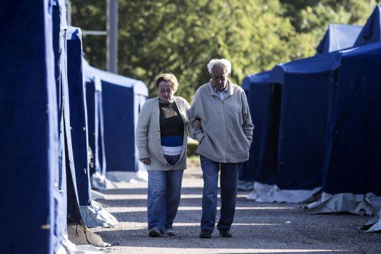 Una pareja camina entre las tiendas de campaña que alojan a los damnificados por el terremoto en Amatrice